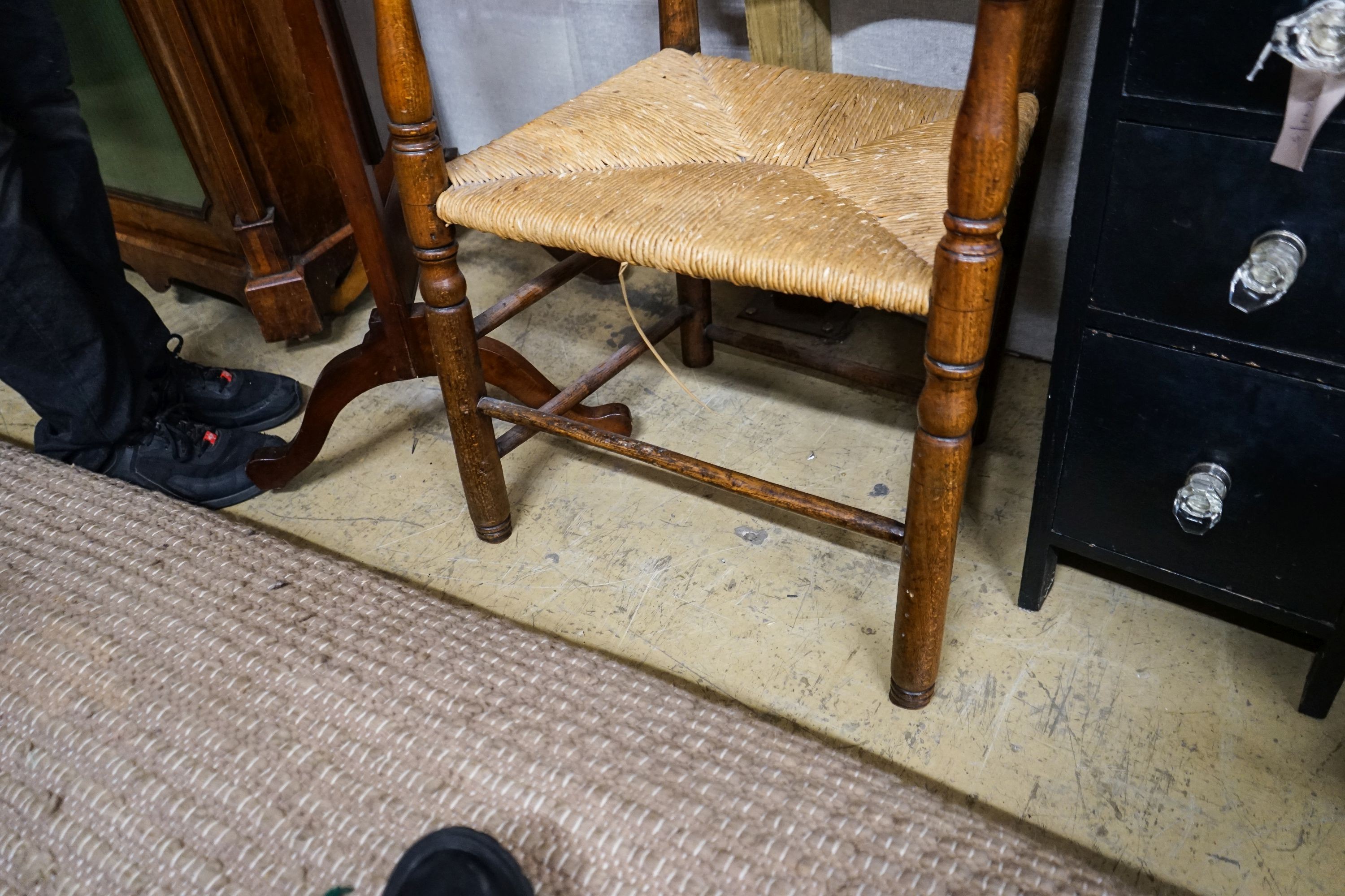 An early 19th century ash and elm rush seated ladder back elbow chair, width 63cm, depth 44cm, height 107cm